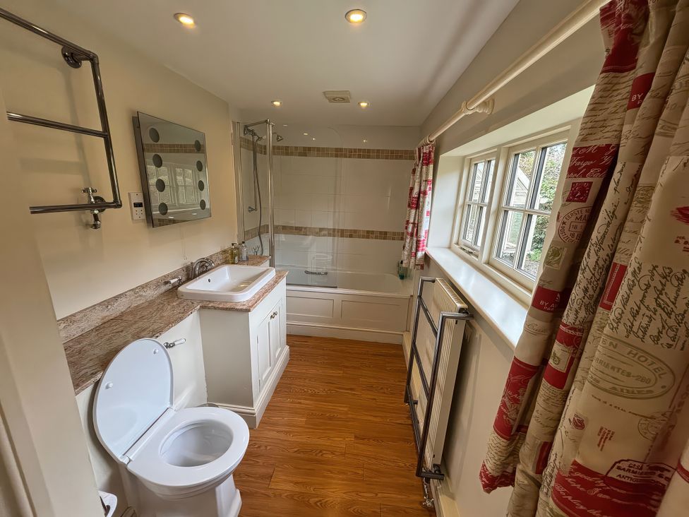 A bathroom with a toilet, sink, and shower at New Barn in Broad Chalke