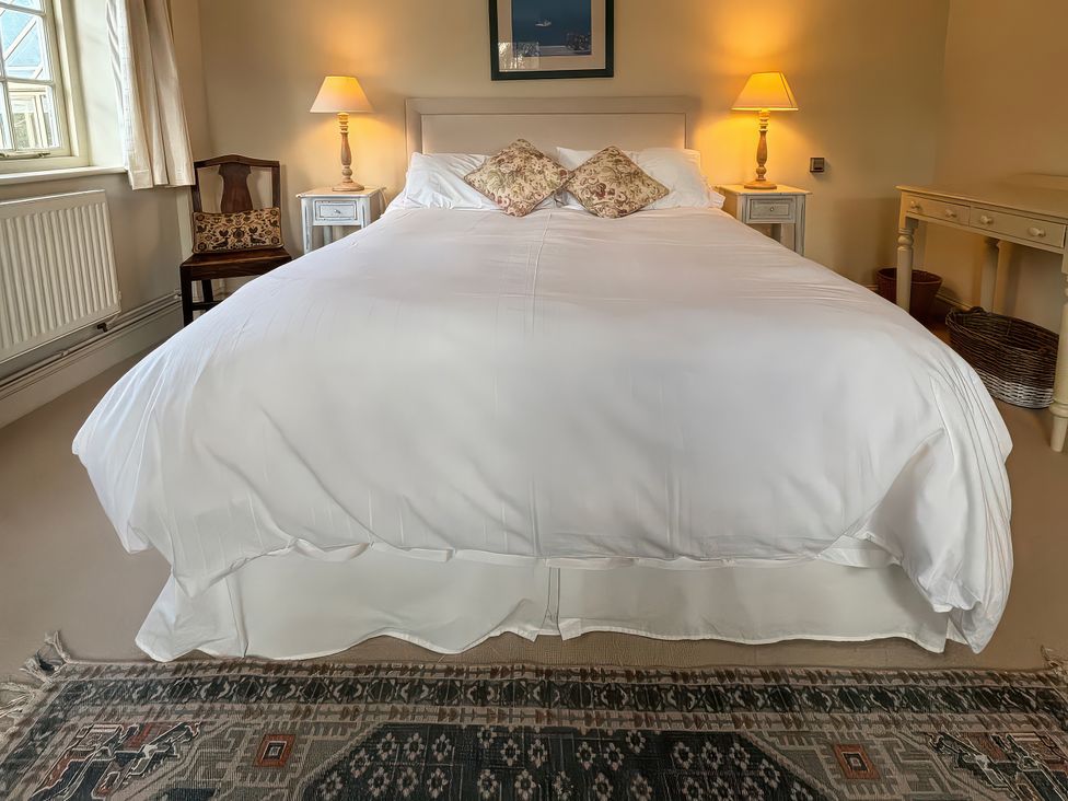 A bedroom with a bed and a lamp at New Barn in Broad Chalke