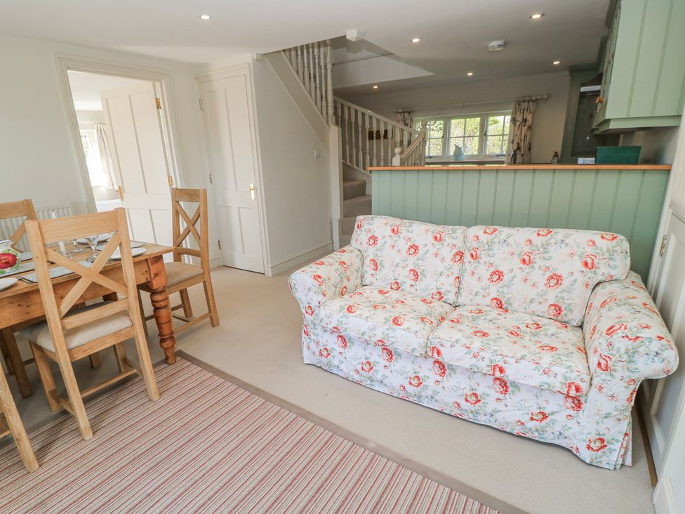 A living room with a sofa and dining area at New Barn in Broad Chalke