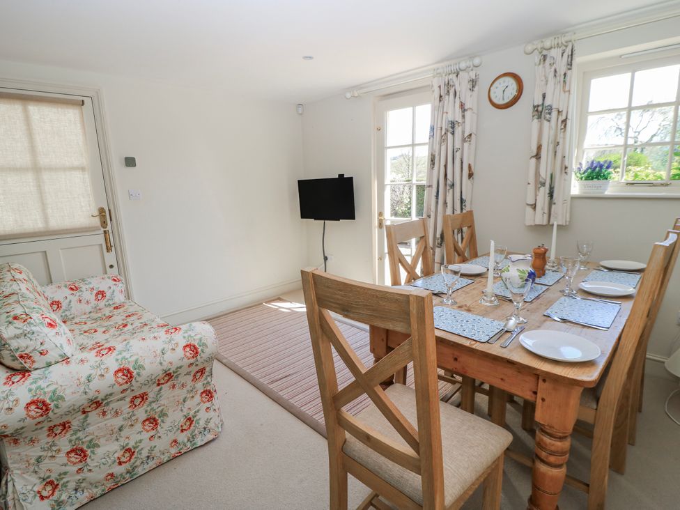 A dining room with a table and chairs at New Barn in Broad Chalke