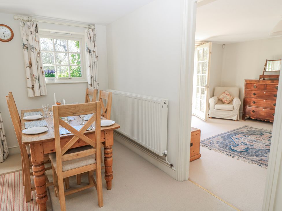 A dining room featuring a wooden table with chairs at New Barn in Broad Chalke