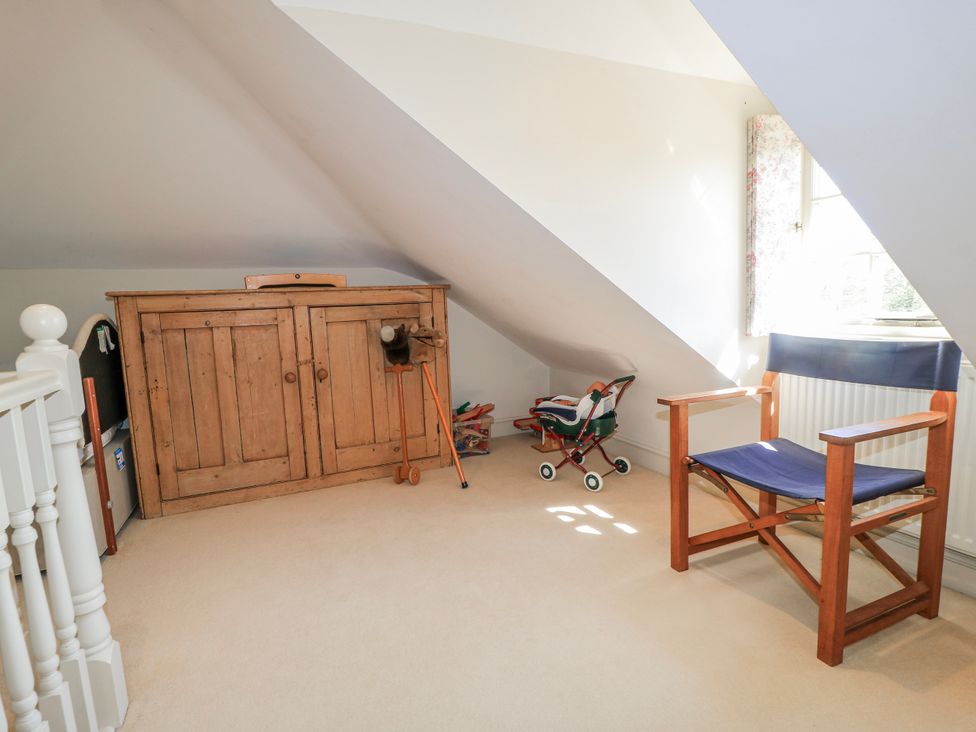 An attic with a storage cabinet and chair at New Barn in Broad Chalke