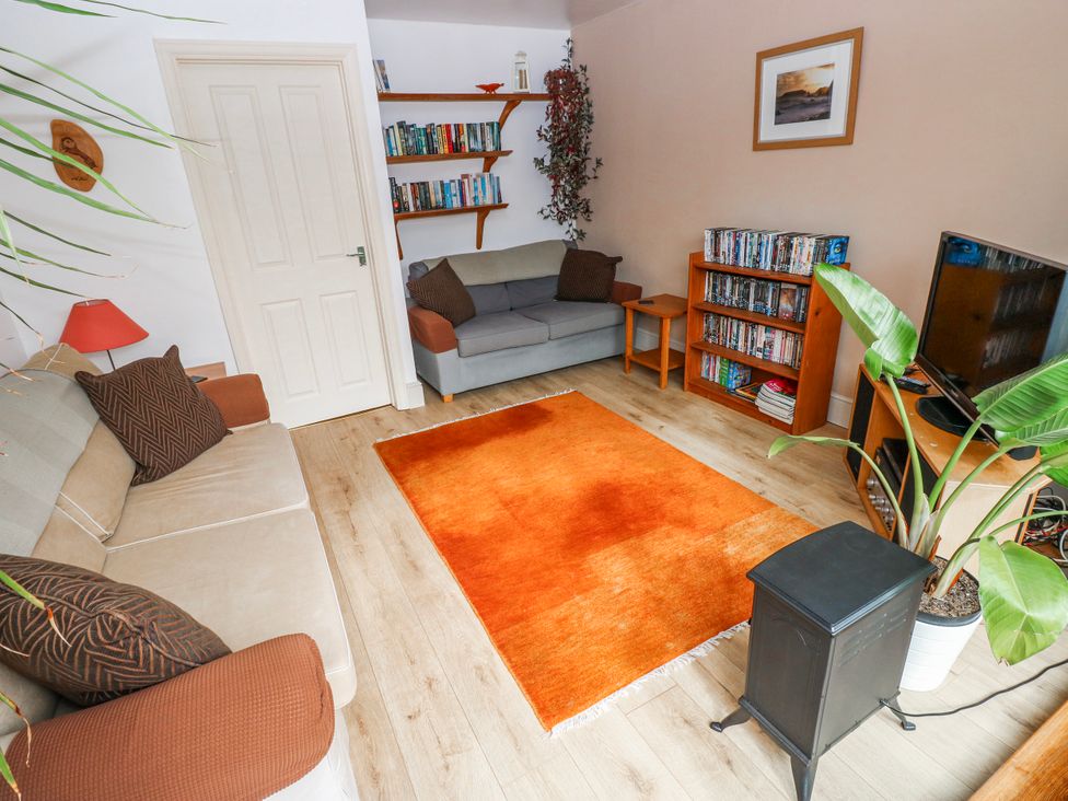 A living room with a sofa and bookshelf at The Cwtch in Haverfordwest