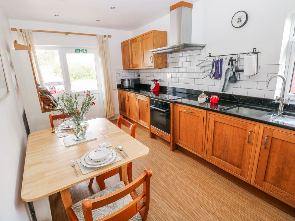 A kitchen with a dining table and chairs at The Cwtch in Haverfordwest