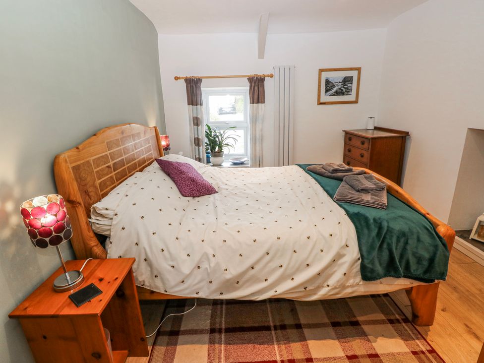 A bedroom with a bed and bedside table at The Cwtch in Haverfordwest