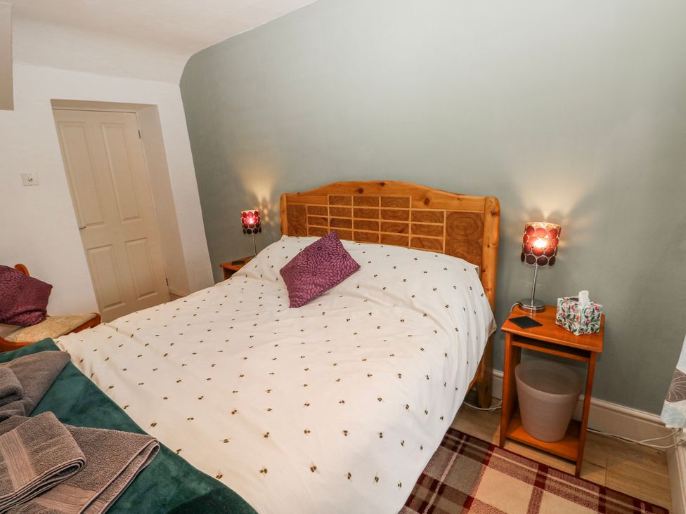 A bedroom with a bed and bedside tables at The Cwtch in Haverfordwest
