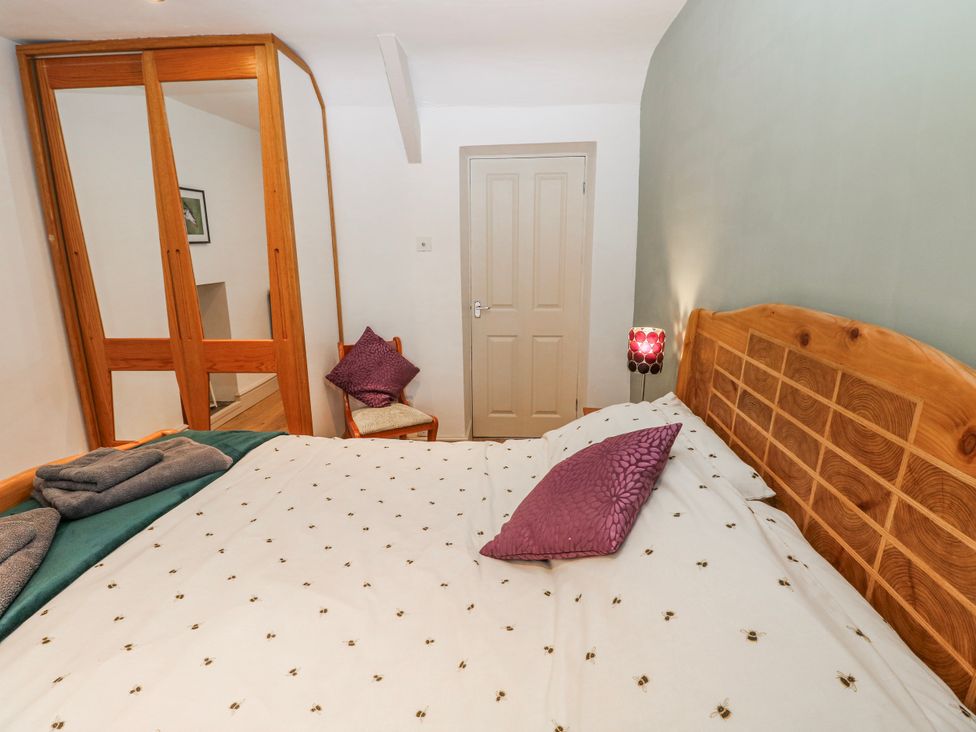 A bedroom with a bed and wardrobe at The Cwtch in Haverfordwest