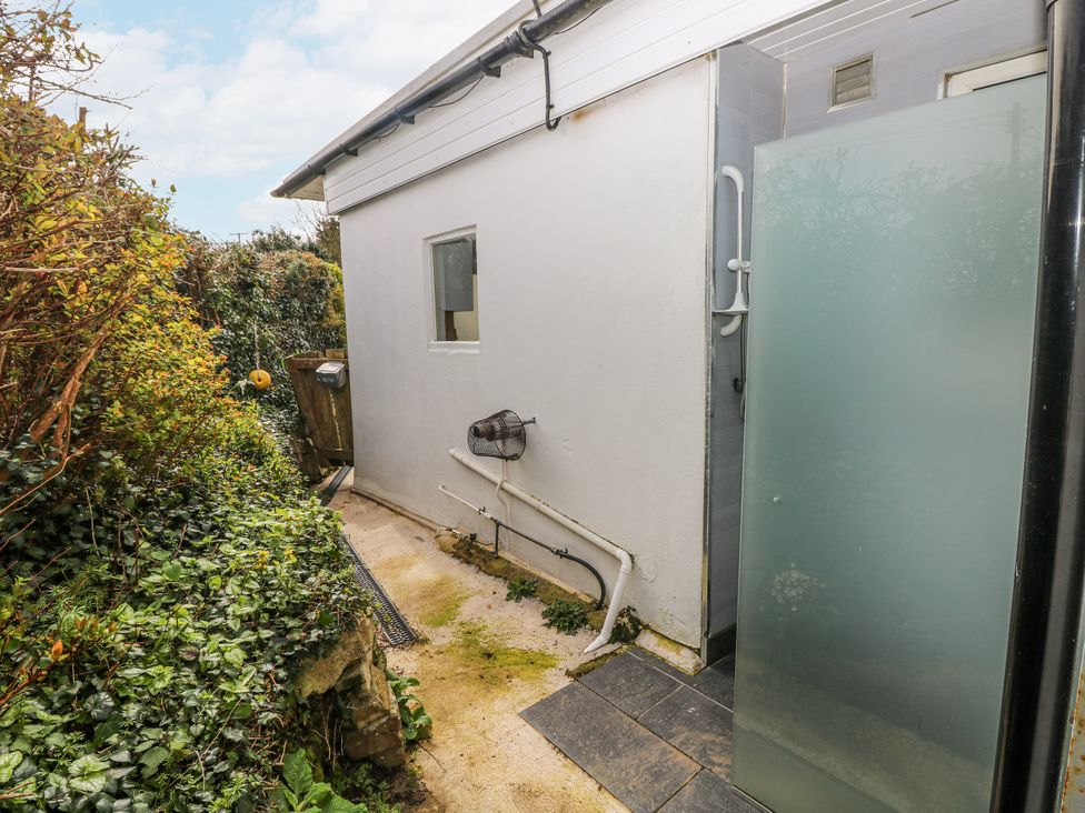 An outdoor shower area with a privacy screen at The Cwtch in Haverfordwest