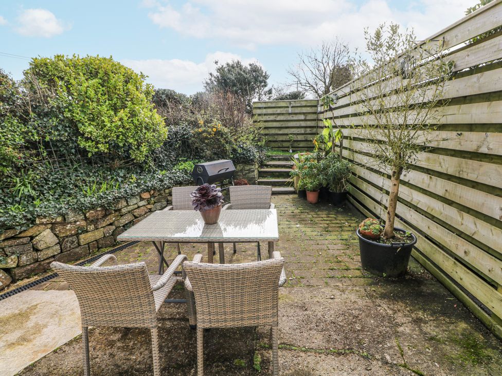 A garden with a patio table and chairs and plants at The Cwtch in Haverfordwest