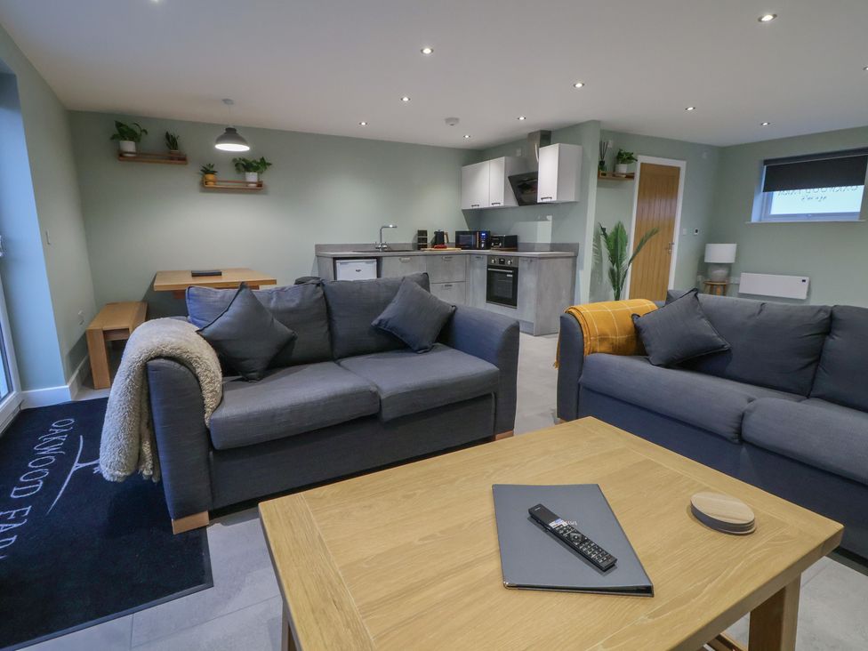 A living room with a sofa and dining table at Ash Barn Chester