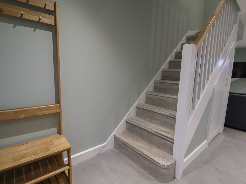 A hallway with stairs and coat rack at Ash Barn in Chester