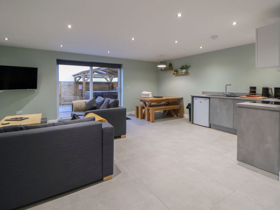 A living room with a sofa and dining area at Ash Barn in Saughall