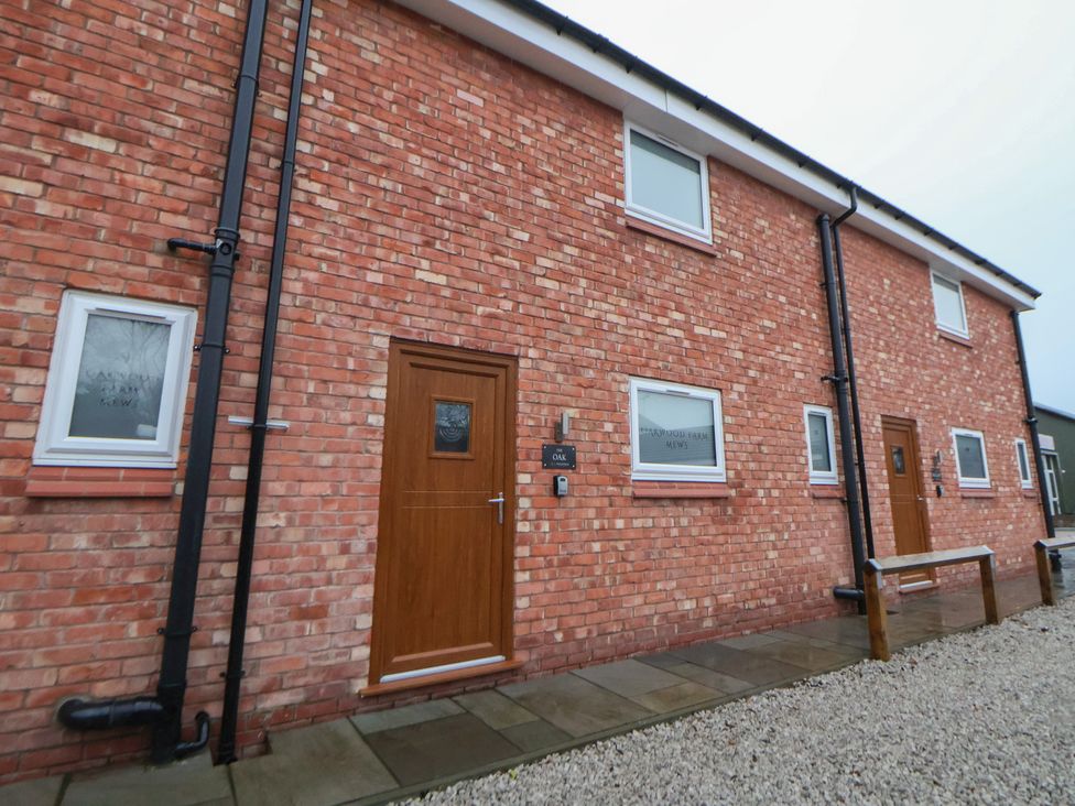 An outdoor view of a brick building with windows and doors at Oak Barn in Chester