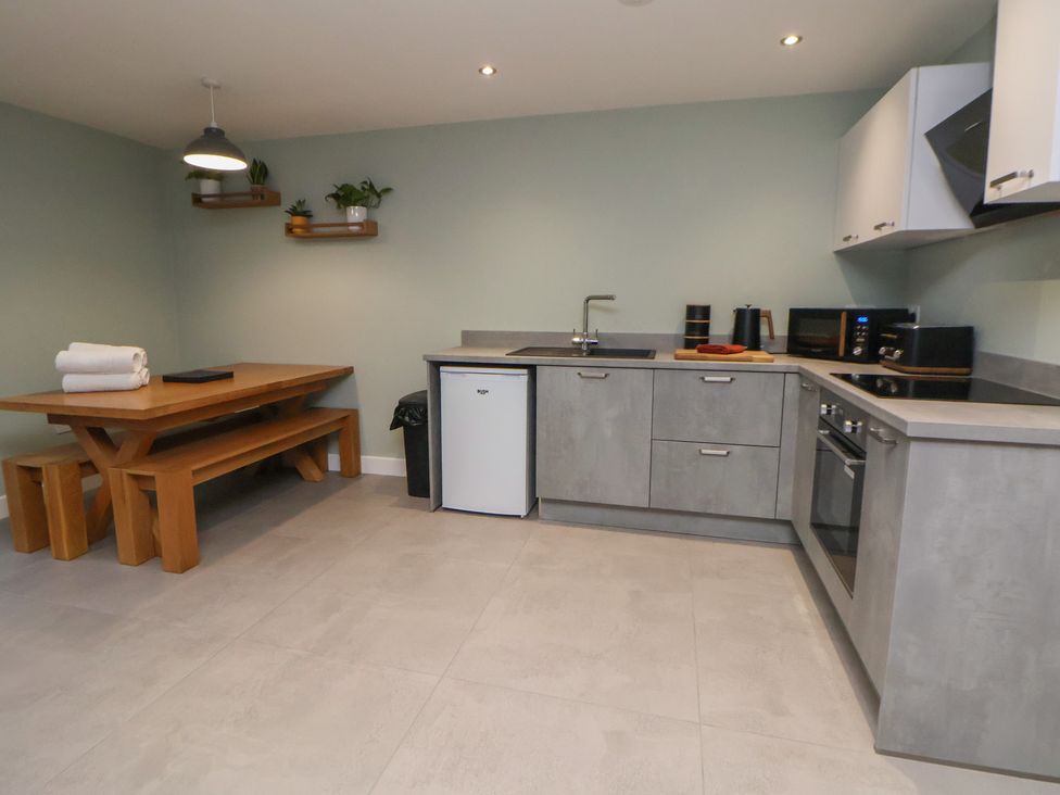 A kitchen with a dining table and appliances at Oak Barn in Chester