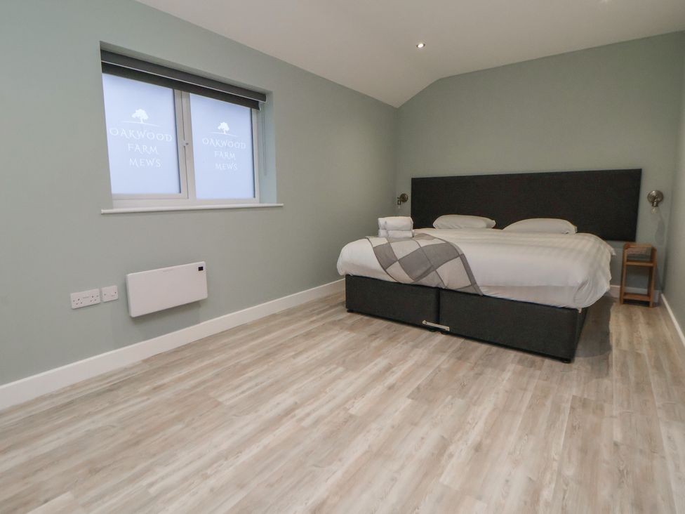 A bedroom with a bed and side table at Oak Barn in Chester
