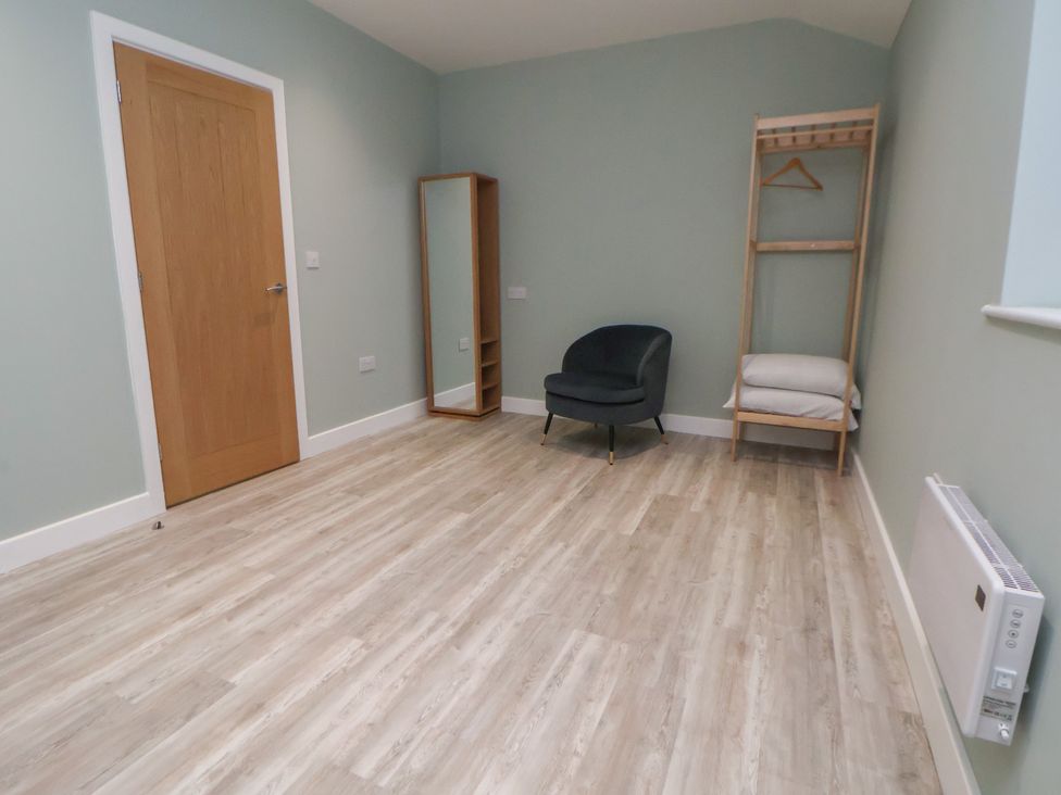 A bedroom with a mirror and chair at Oak Barn Chester