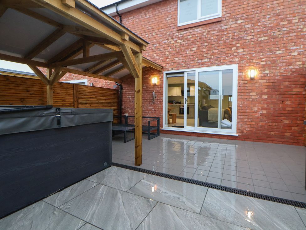 A garden with a hot tub and covered seating area at Oak Barn, Chester