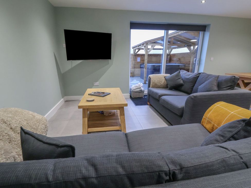 A living room with a television and a coffee table at Oak Barn in Saughall