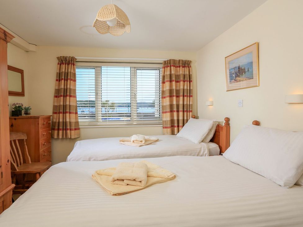 A bedroom with two beds and a window at 3 The Salcombe, Salcombe