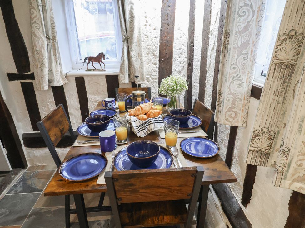 A dining table set with blue plates and croissants at Driftway Cottage in Diss