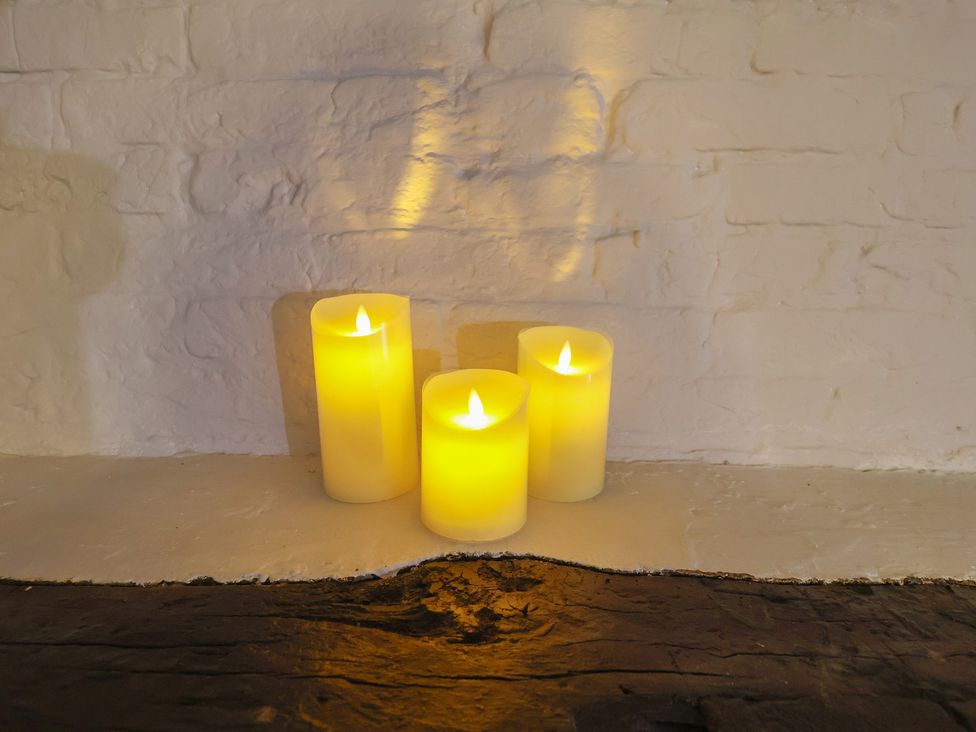 Three candles on a surface at Driftway Cottage in Diss