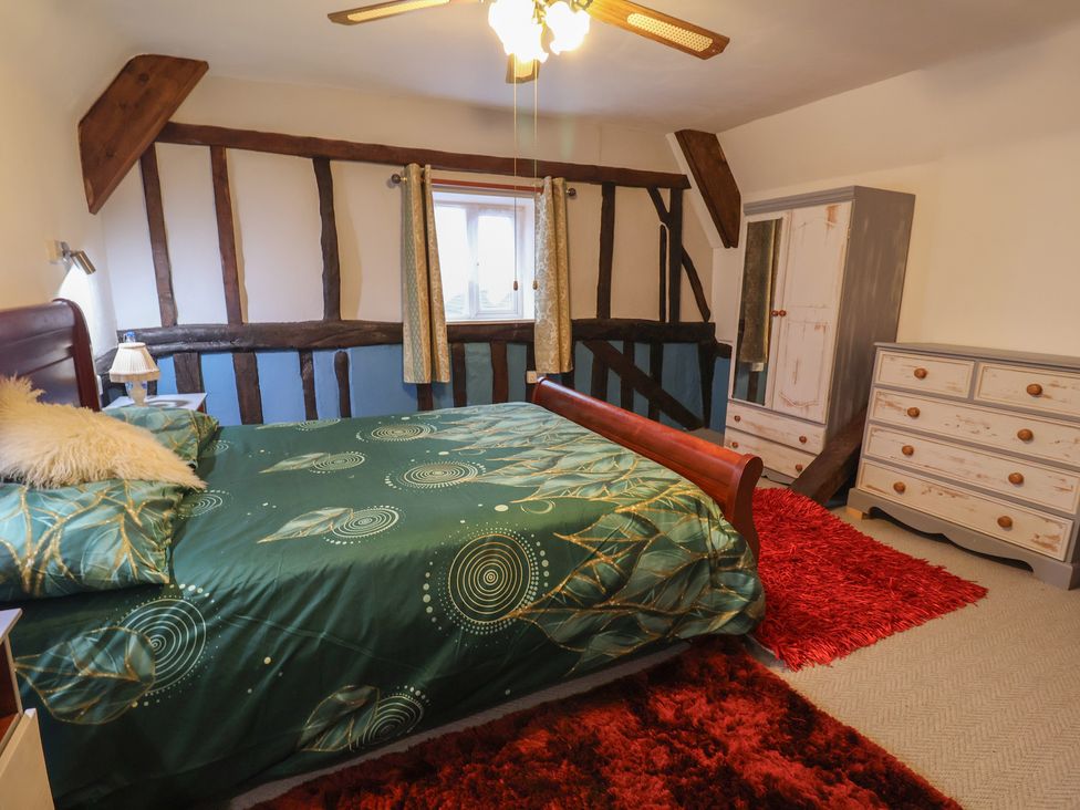 A bedroom with a bed and wardrobe at Driftway Cottage in Diss