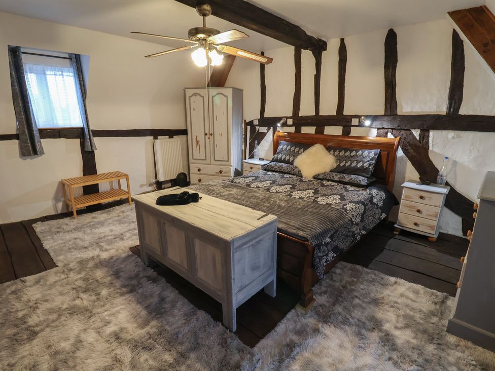 A bedroom with a bed and wardrobe at Driftway Cottage in Diss