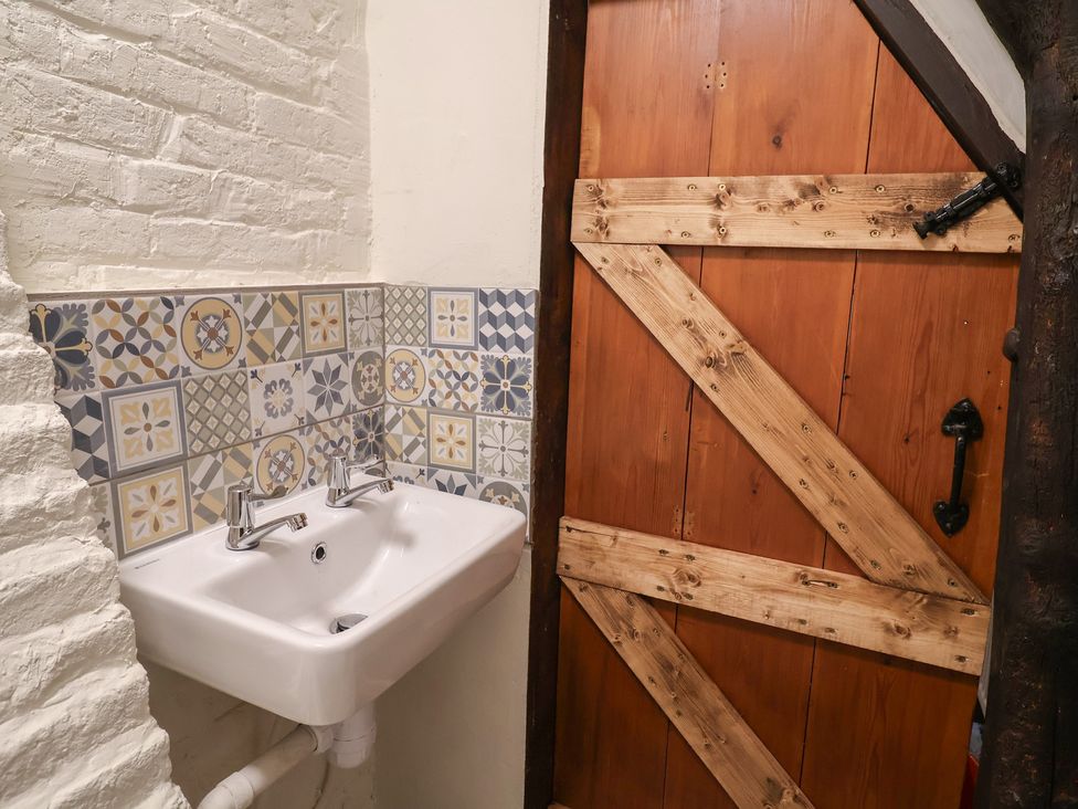 A bathroom with a sink and door at Driftway Cottage in Diss