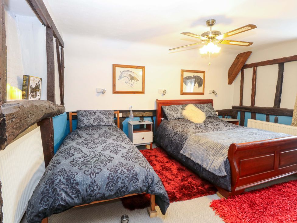 A bedroom with two beds and wooden beams at Driftway Stables Retreat in Diss