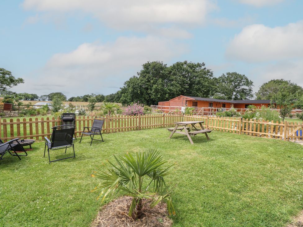 A garden with chairs and a picnic table at Driftway Stables Retreat in Diss