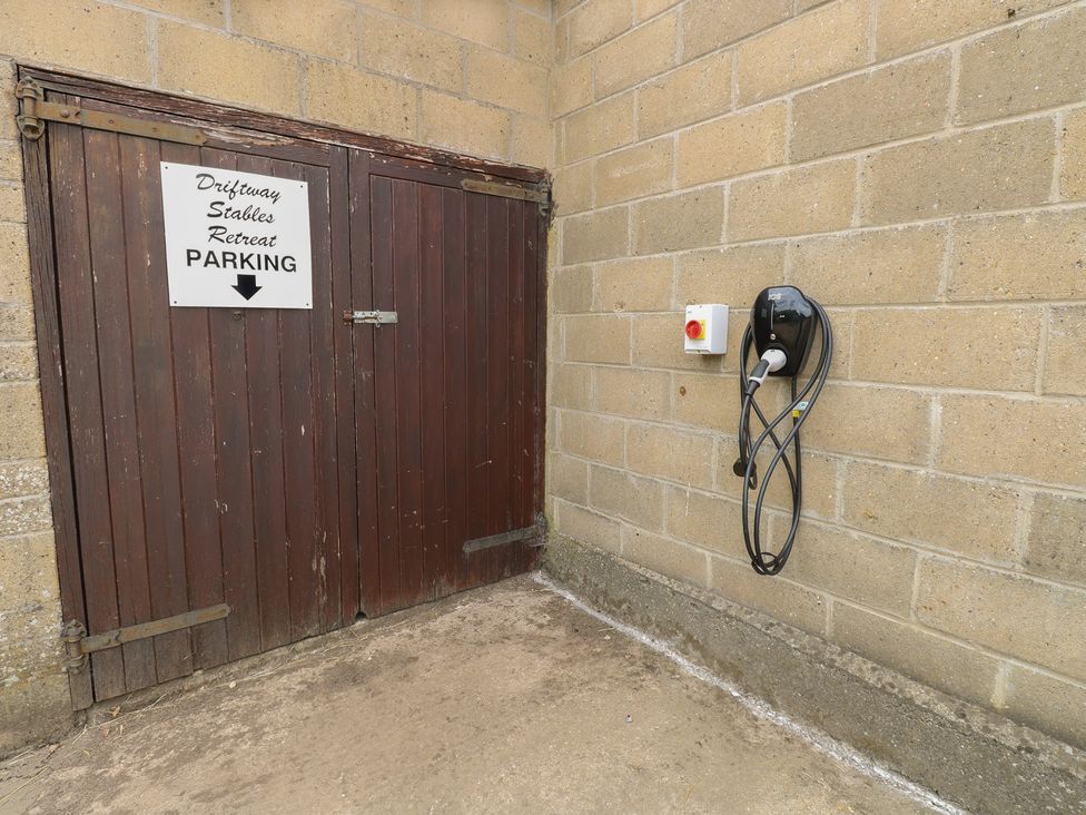 A parking sign and electric charging station at Driftway Stables Retreat in Diss