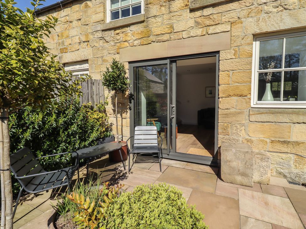 An outdoor area with chairs and a table at Snowdrop Cottage near Warkworth