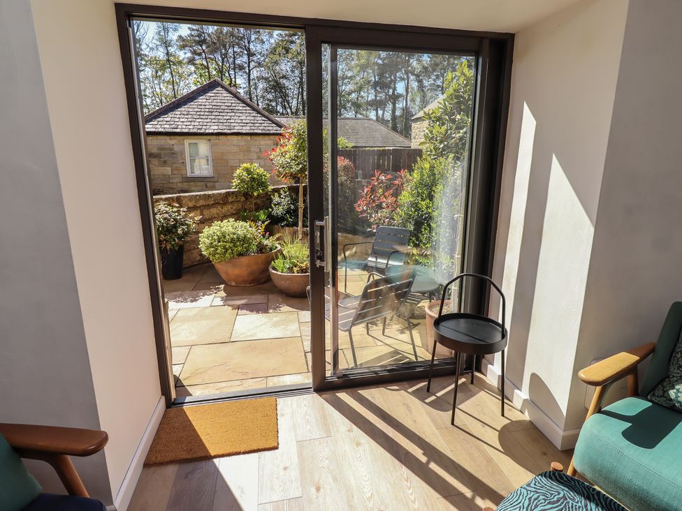A snug with a glass door opening to a garden at Snowdrop Cottage near Warkworth