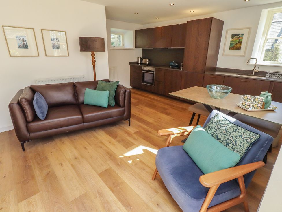 A living room with furniture and kitchen area at Snowdrop Cottage near Warkworth