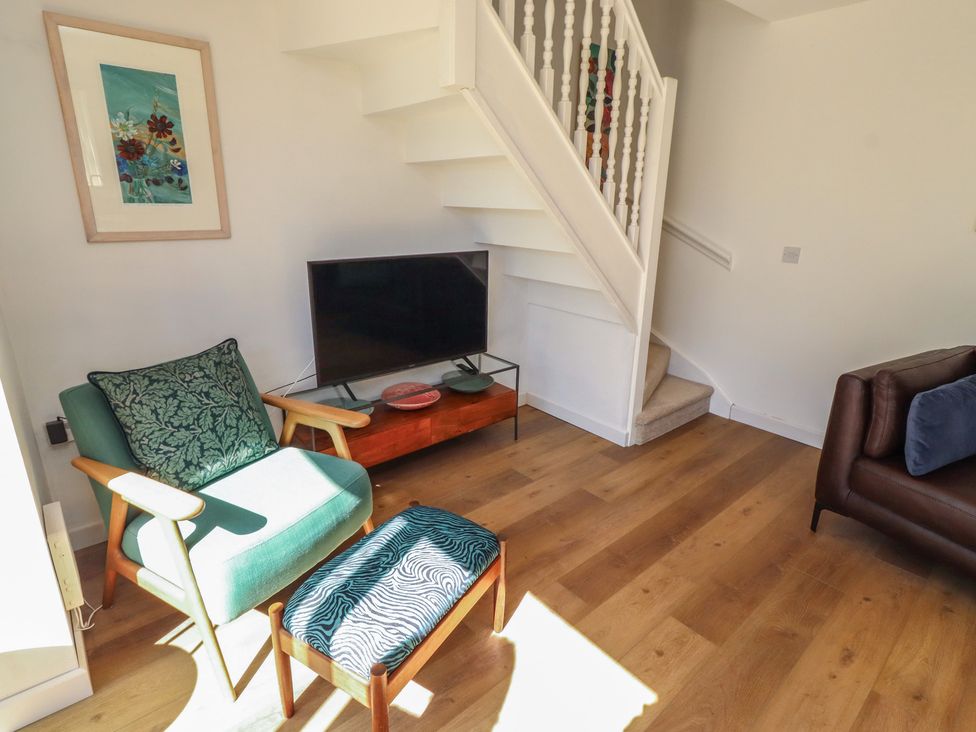 A living room with a television and seating at Snowdrop Cottage near Warkworth