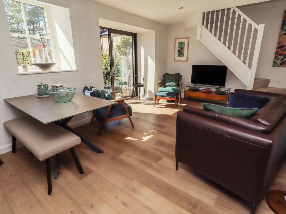 A living room with furniture and a television at Snowdrop Cottage near Warkworth