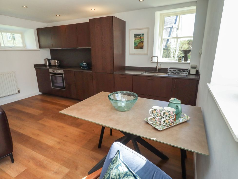 A kitchen with modern appliances and a dining table at Snowdrop Cottage near Warkworth