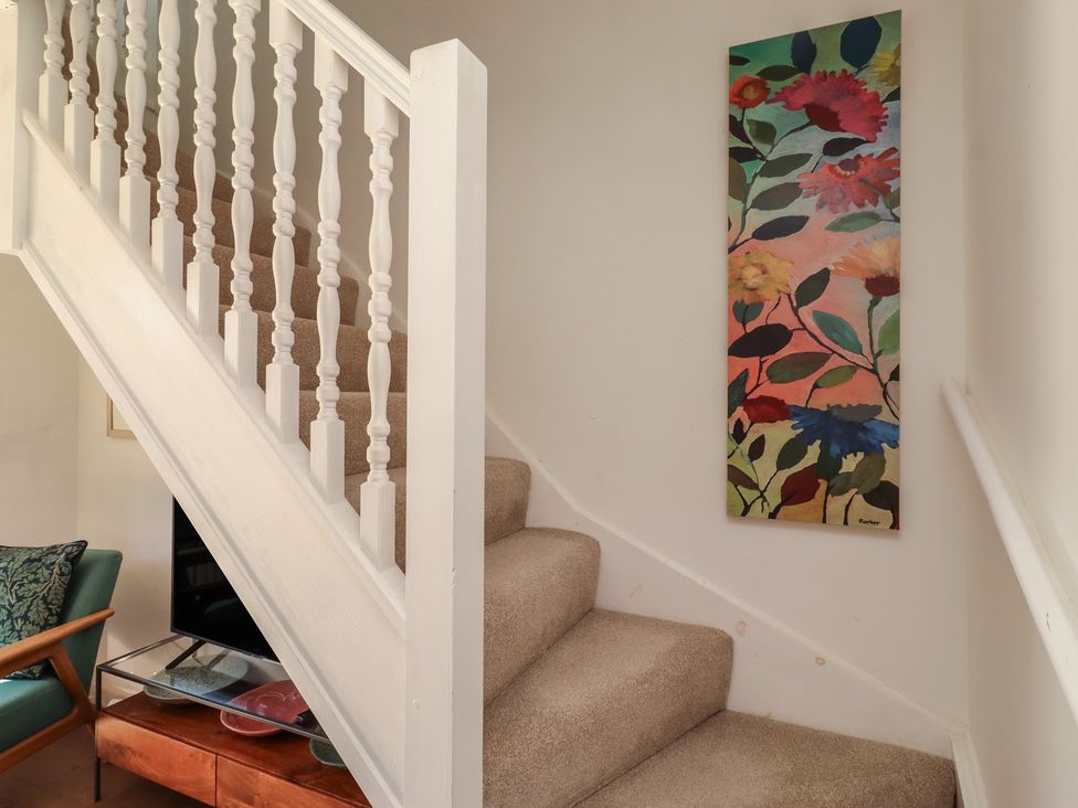 A staircase with wall art and a handrail at Snowdrop Cottage near Warkworth