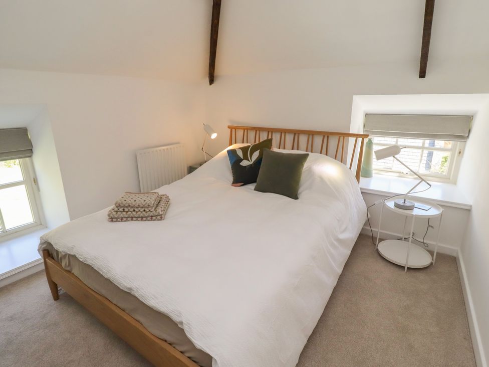 A bedroom with a bed and lamp at Snowdrop Cottage near Warkworth