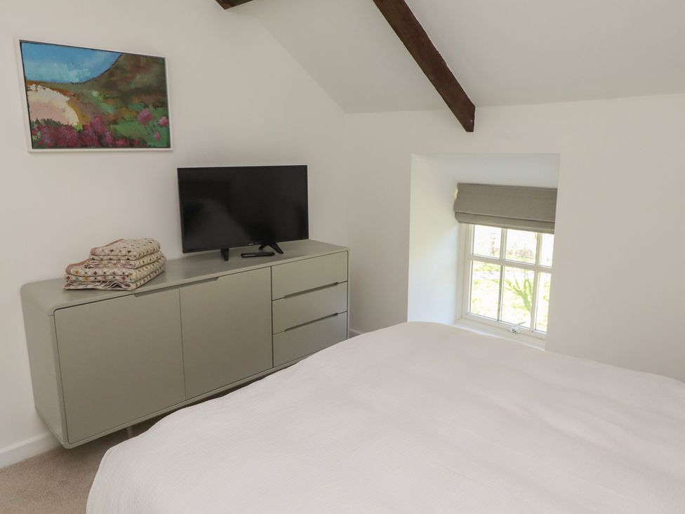 A bedroom with a television and a dresser at Snowdrop Cottage near Warkworth