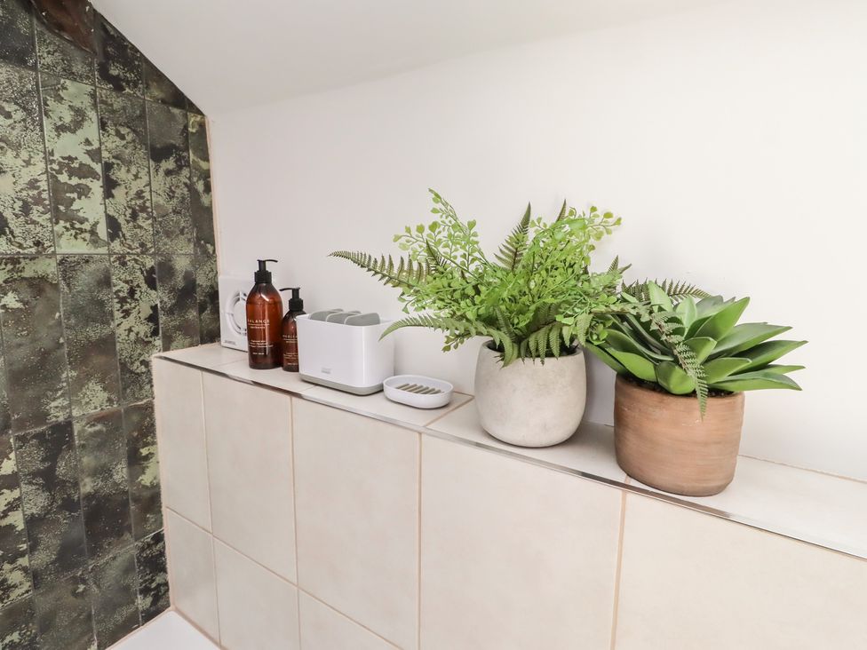 A bathroom with plants and containers on a counter at Snowdrop Cottage near Warkworth