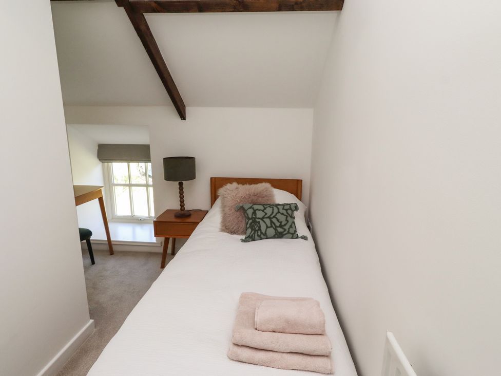 A bedroom with a bed and a lamp at Snowdrop Cottage near Warkworth