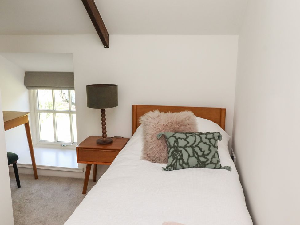A bedroom with a bed and lamp at Snowdrop Cottage near Warkworth
