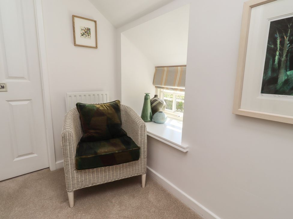 A sitting room with an armchair and window at Snowdrop Cottage near Warkworth