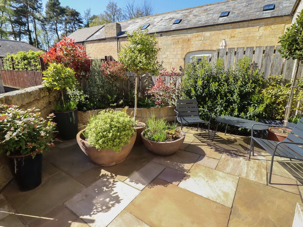 A small garden with plant pots and furniture at Snowdrop Cottage near Warkworth