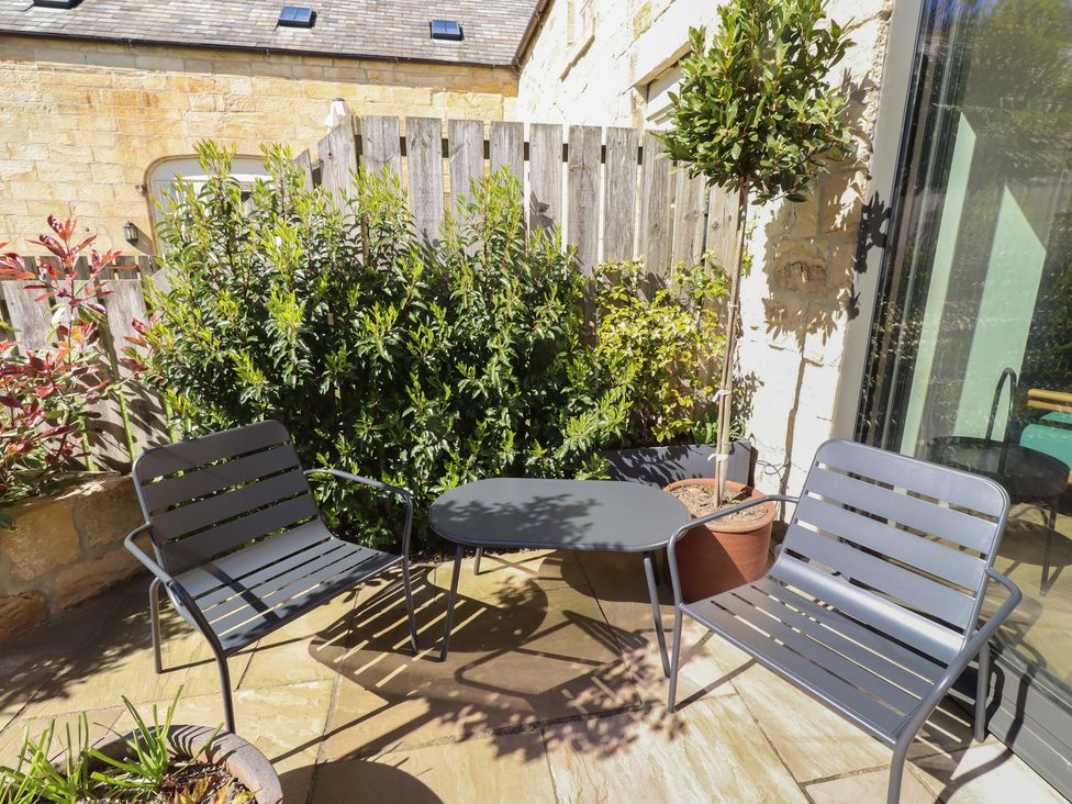An outdoor seating area with two chairs and a table at Snowdrop Cottage near Warkworth