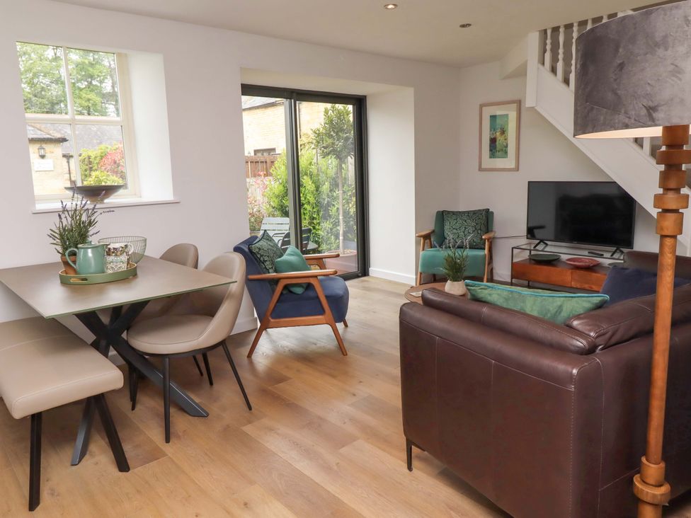 A living room with a dining area and seating at Snowdrop Cottage near Warkworth