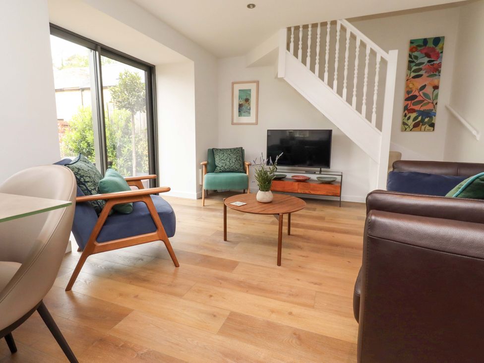 A living room with a staircase and furniture at Snowdrop Cottage near Warkworth