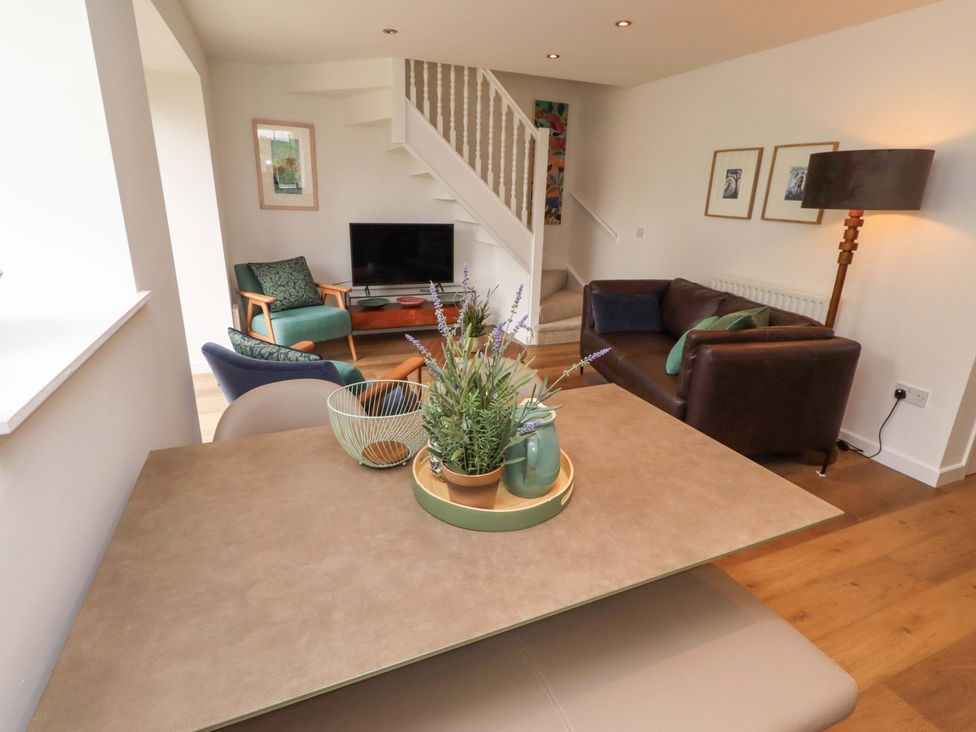 A living room with a table and sofa at Snowdrop Cottage near Warkworth