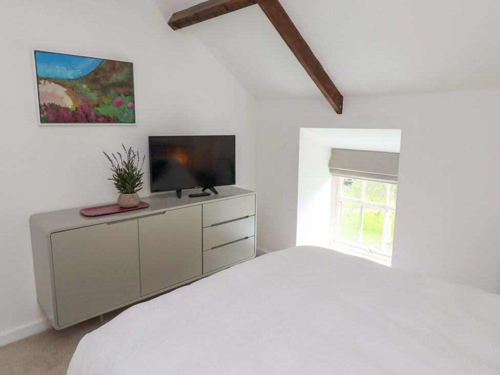 A bedroom with a television and dresser at Snowdrop Cottage near Warkworth